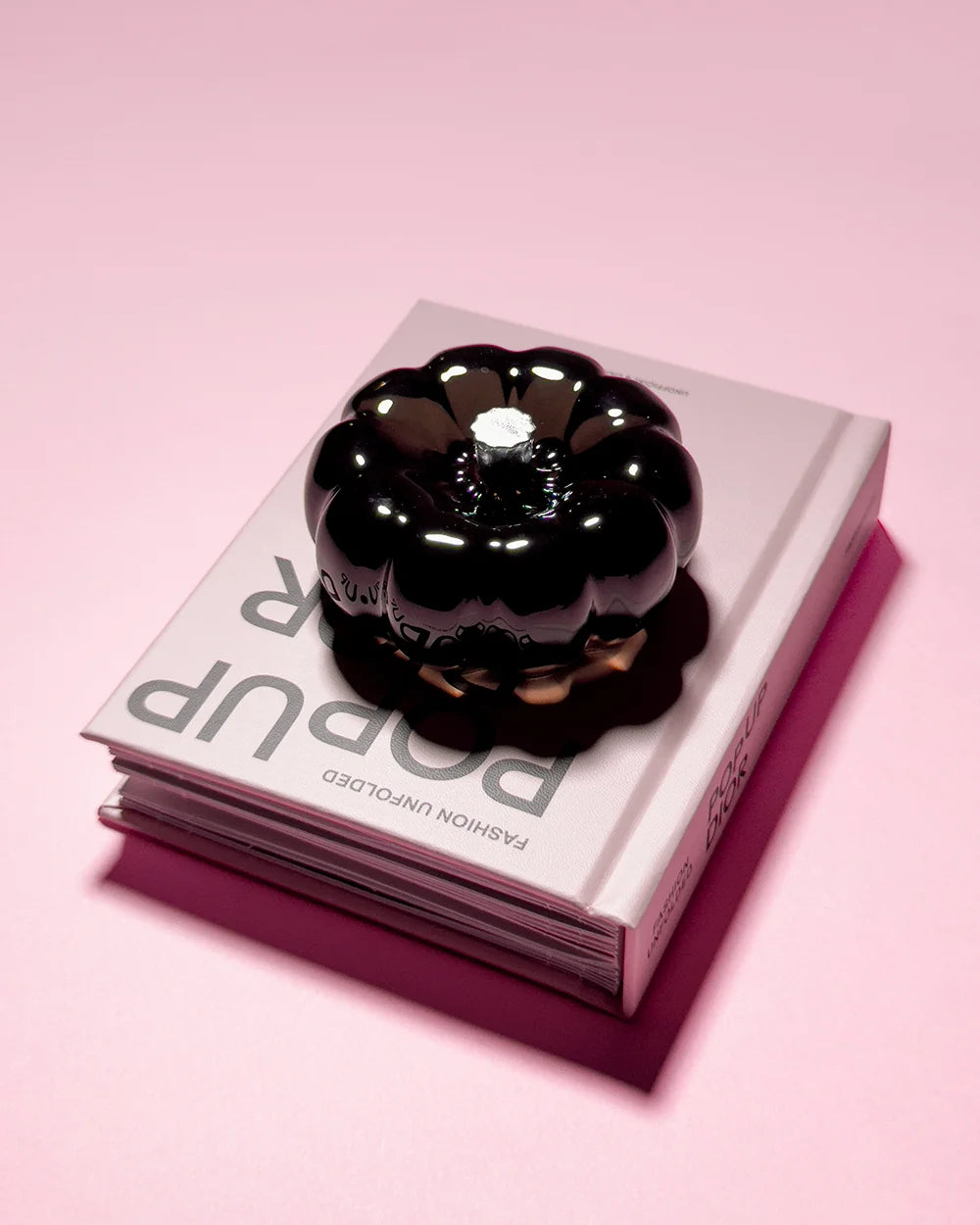 Glossy black resin specimen by momu. Mysterious dark archival fragment with a sleek, reflective finish.